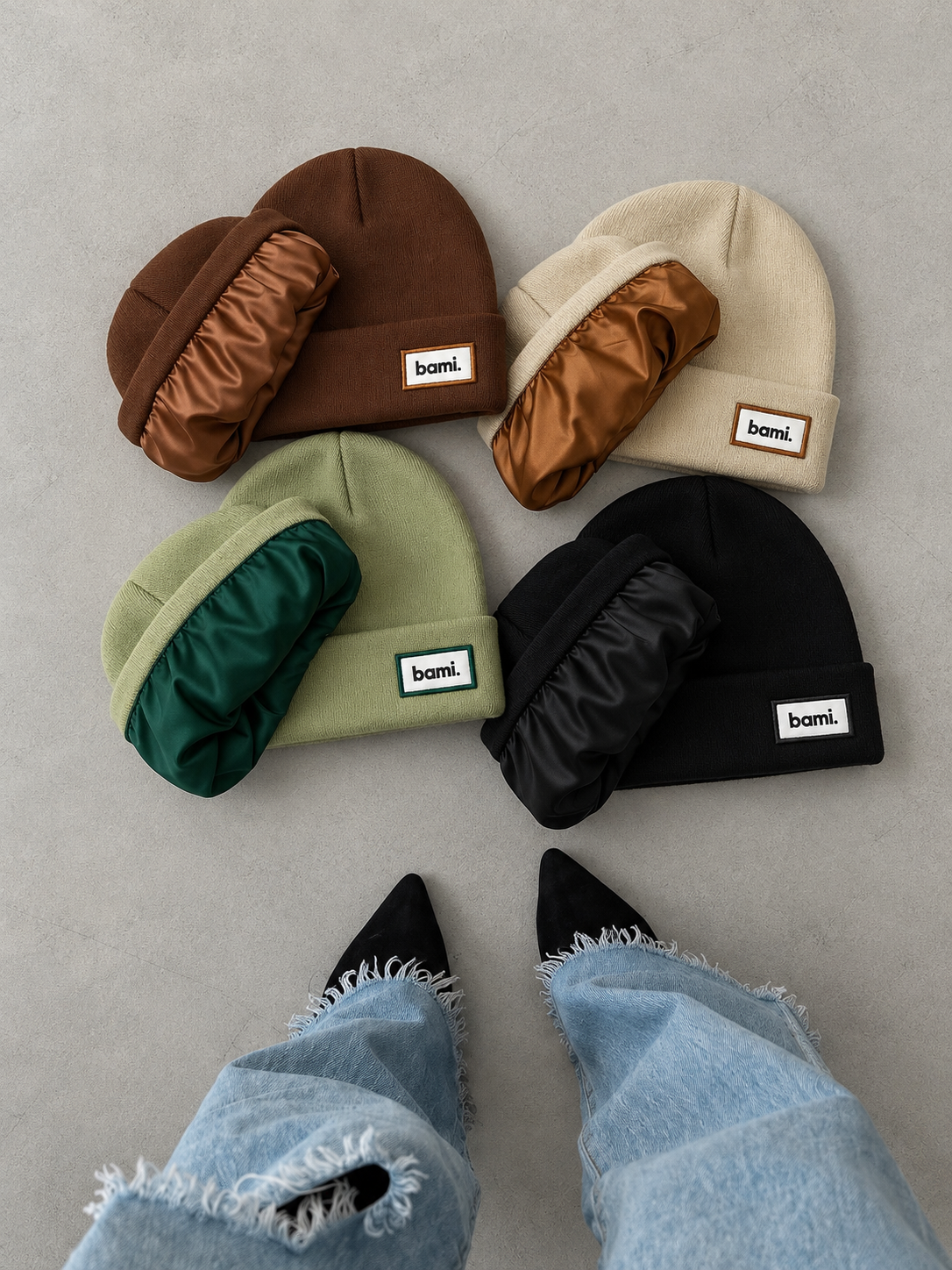 Quatre bonnets BAMI posés au sol, la doublure en satin sortie pour montrer l'intérieur