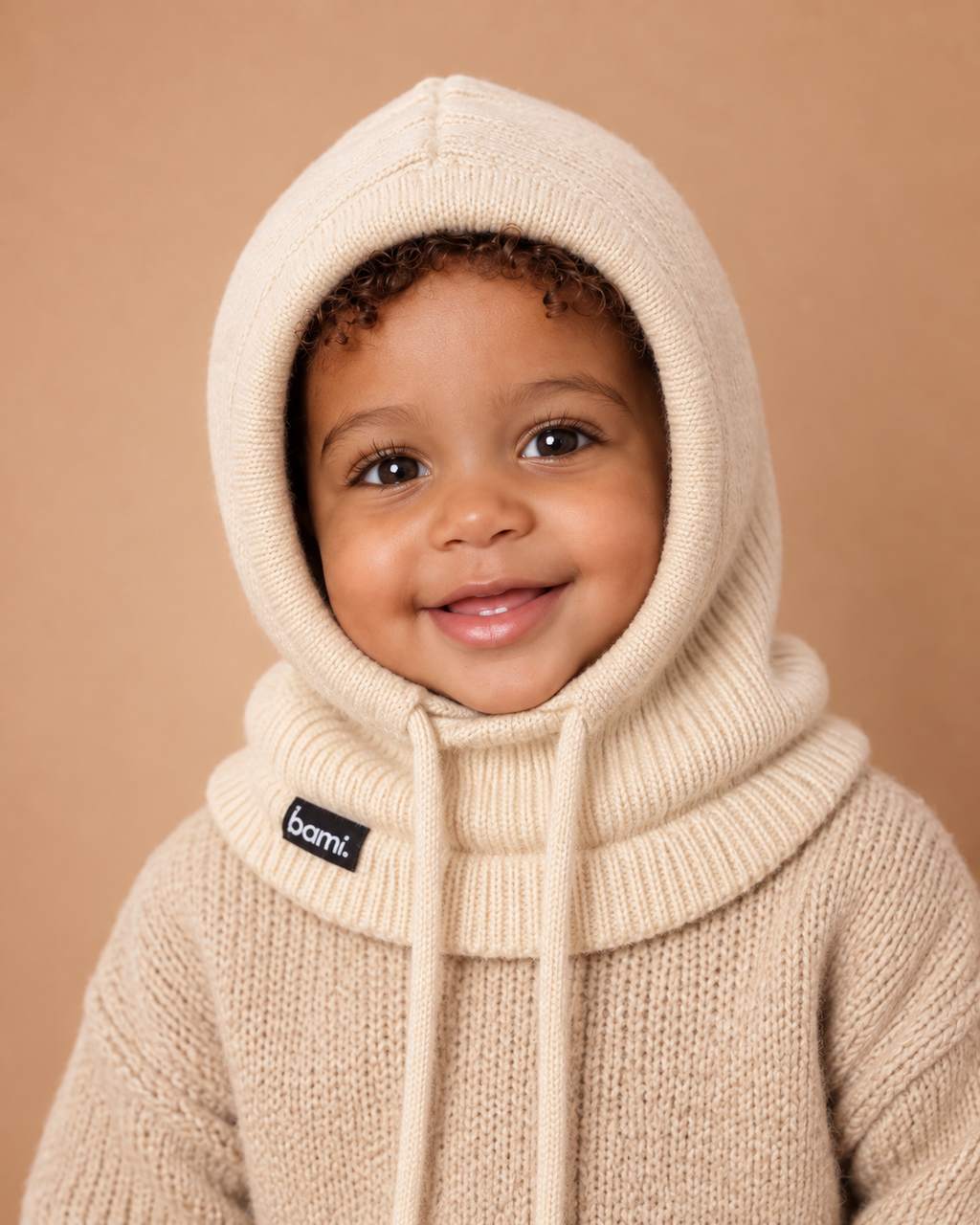 Cagoule BAMI™ doublée satin beige portée par un bébé