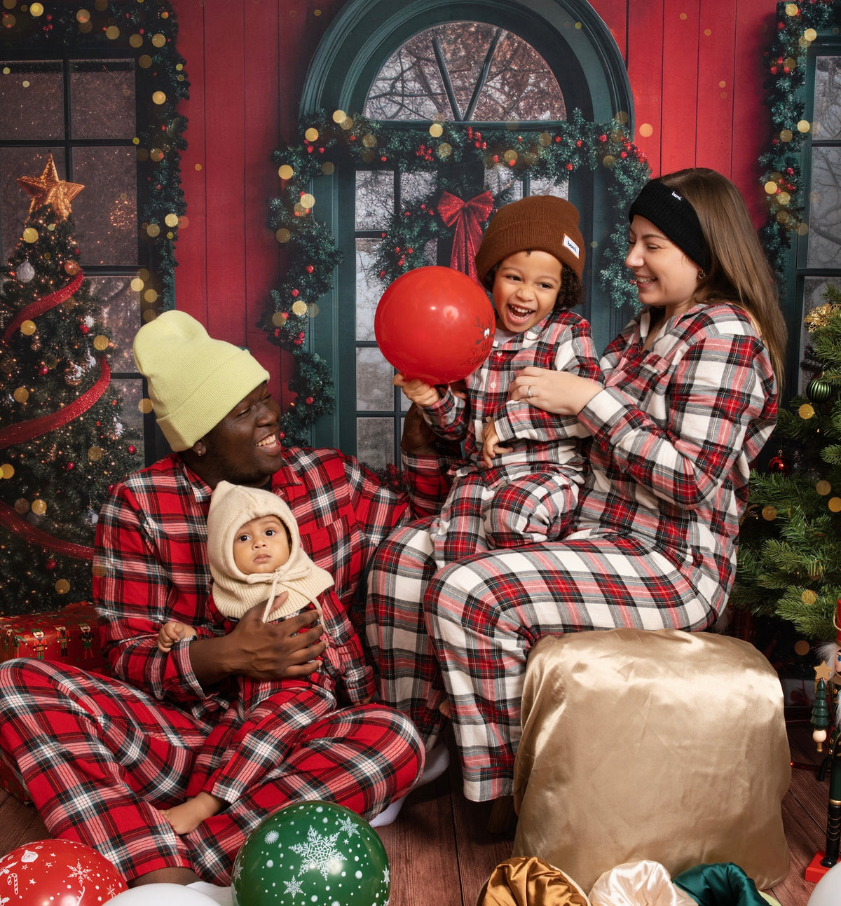 La famille BAMI en pyjamas assortis devant un décor de Noël, les enfants portant des bonnets BAMI